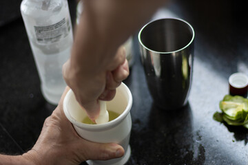 preparando uma caipirinha tipicamente  brasileira com limao, açucar e vodka juntamente com a...