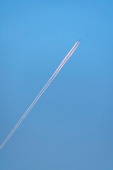 Diagonal contrail behind a climbing airplane day light