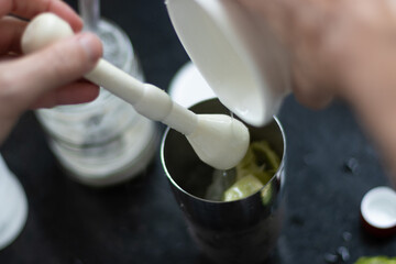 preparando uma caipirinha tipicamente  brasileira com limao, açucar e vodka juntamente com a coqueteleira