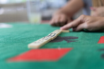 pessoas jogando domin&oacute; sobre mesa de jogos durante a quarentena