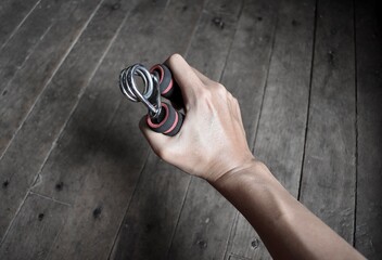 Asian, Chinese young man’s right hand gripping hand exercise gripper.