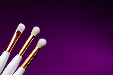 Makeup flat lay brushes yellow  and purple background. Horizontal top view copyspace. Beauty and make up