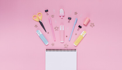 Back to school concept notepad, pencil case, stationery and school supplies. Top horizontal view copyspace pink abstract background
