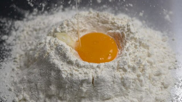 Egg falling into flour, Close-up and slow motion