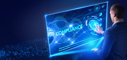 Business, Technology, Internet and network concept. Young businessman working on a virtual screen of the future and sees the inscription: Compliance