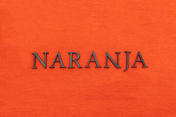 Fototapeta na wymiar Closeup to an orange spanish word black lettering over orange texture at background. Color and fashion concept