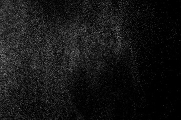 Abstract splashes of water on black background. Freeze motion of white particles. Rain, snow overlay texture.