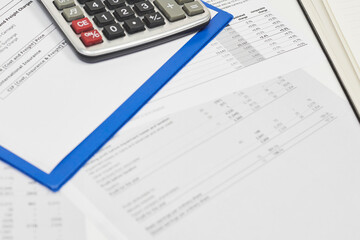 Obraz premium Calculating export import cost. Stack of statistic data, calculator and notepad. Detailed reviewing export import tariffs