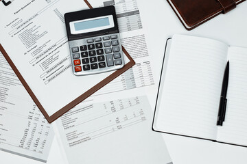 Calculating export import cost. Stack of statistic data, calculator and notepad. Detailed reviewing...