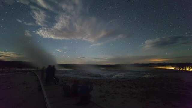 Lockdown time lapse shot of tourists on boardwalk by geyser against sky at night - Yellowstone National Park, Wyoming
