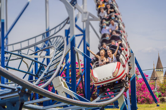 Happy friends in amusement park on a summer day