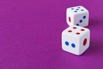 Dice on a purple background. Close up. The concept of luck in gambling.