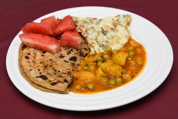aloo roti tandoori roti or paratha, parantha with spicy  jeera / masala aloo mutter or aloo ki sabzi potato curry traditional Indian breakfast recipe Jaipur Rajasthan, India.  Made with whole wheat 