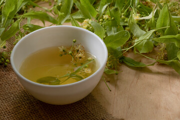 Tea from linden. Fresh flowering linden on a wooden background. Healthy and natural tea. June linden harvest. Healthy.