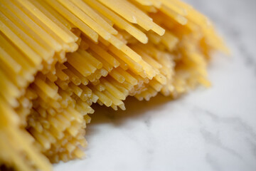 Yellow long spaghetti on a rustic background. Yellow italian pasta. Long spaghetti. Raw spaghetti bolognese. Raw spaghetti. Food background concept. Italian food and menu concept.
