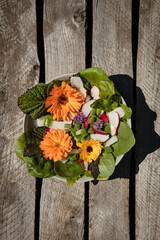 Schale mit Salat auf braunem Holzuntergrund - 357754480