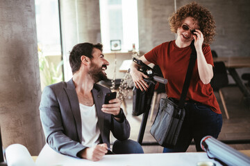 Colleagues in office. Businesswoman and businessman discussing work in office. Two friends in working together.	