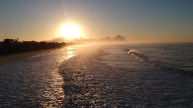 DRONE SUNRISING WITH WAVES CRASHING