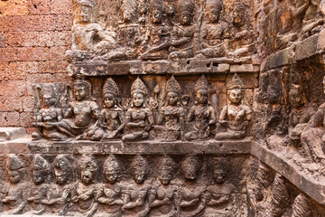 Carved wall with female dancers (apsaras) wearing pointed diadems and swords. Terrace of the Leper King. Angkor area, Siem Reap, Cambodia, South east Asia