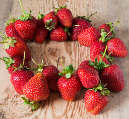 Closeup of red juicy strawberries laid out on a wooden table