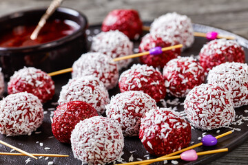 Energy berry balls on a black plate, close-up