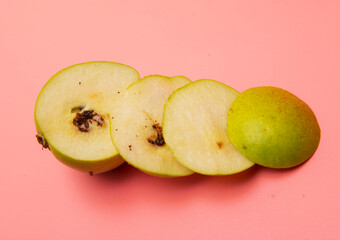 cut pear with a worm on a pink background