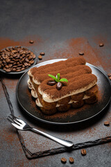 Classic tiramisu dessert on ceramic plate on concrete background