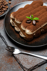 Classic tiramisu dessert on ceramic plate on concrete background