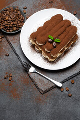Classic tiramisu dessert on ceramic plate on concrete background