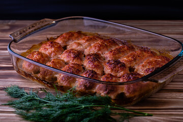 Fried meat cutlets were taken out of the oven on a baking tray on a wooden table.