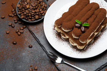 Classic tiramisu dessert on ceramic plate on concrete background