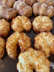 Close up of fresh baked butter croissants in the foreground plus some mild and sweet coffee flavor mocha bread in the background place on tray in pastry shop.