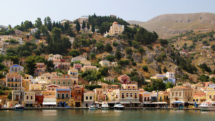Fototapeta na wymiar Symi town, Symi island, pictorial view of colorful houses and the harbour 