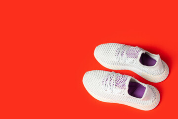 Sports sneakers on a red background. Concept of sport, fashion. Top view, flat lay