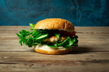 Fresh home-cooked appetizing tasty burger with chicken on wooden table