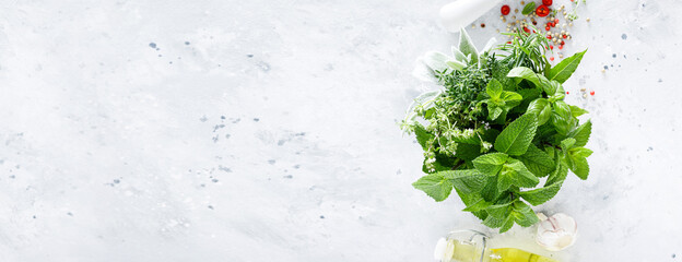 Bunch of aromatic herbs in mortar on kitchen table. Banner