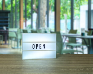 Open text light box sign in blurry restaurant view