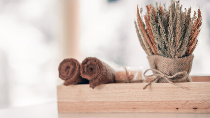 Spa concept. Dry flowers, brown towels, and soap on wood block. soft selective focus
