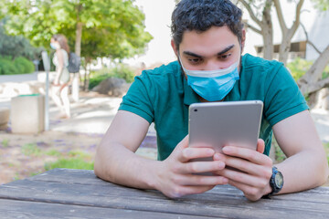 A serious guy watching online media on a tablet