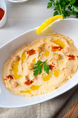 hummus paste with lemon and chilli on white background