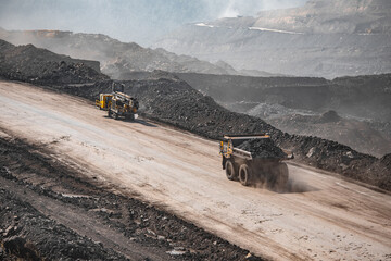 Drilling car and big yellow mining empty truck with dust transportation. Open pit mine industry