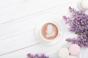 Fototapeta na wymiar Lilac, coffee with latte art on light wooden table. Romantic morning