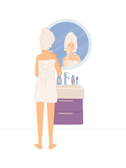 Young woman wearing towel after shower looking at her reflection in round mirror