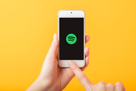 Bangkok, THAILAND, June 3, 2020: Woman hand holding Smart Phone with spotify logo on Apple iPhone SE