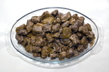 dolma, stuffed grape leaves in a bowl, turkish and greek cuisine . Azerbaijan meal, stuffed grape leaves, rice and spices .