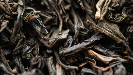 Black large-leaf tea as a background. Texture of dry black tea leaves.