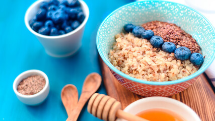 High protein healthy breakfast, buckwheat porridge with blueberries and honey