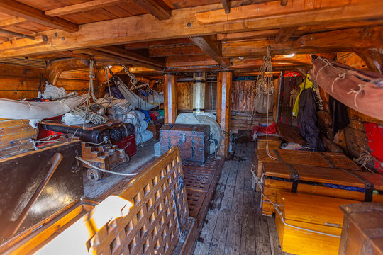 Inner view of a wooden pirate tall ship cabin with canon, chest and folded wings ready to sail away campaigning on the high sea
