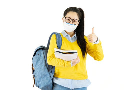 Young Asian Student Woman In Glasses Wearing Medical Face Mask,carrying A Bag To Go To School Under The Outbreak Of The Virus Isolated On White Background