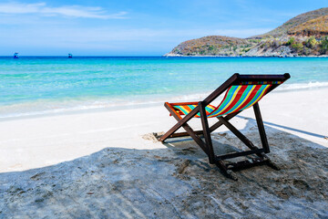 Beach chairs on a sandy beach by the ocean, the concept of relaxation, traveling on a tropical island, relaxation with beautiful views of the bruise sea and blue sky